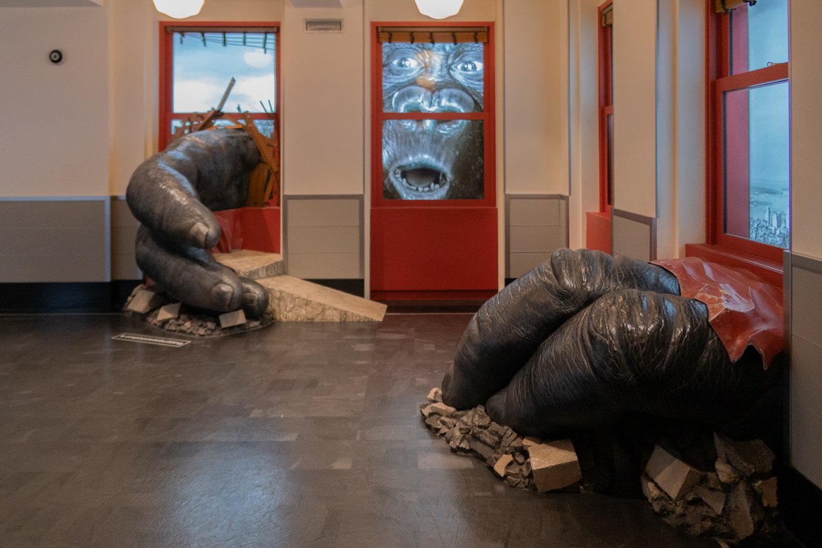 Scène reconstituée dans le bâtiment avec King Kong à la fenêtre et ses mains dans la pièce