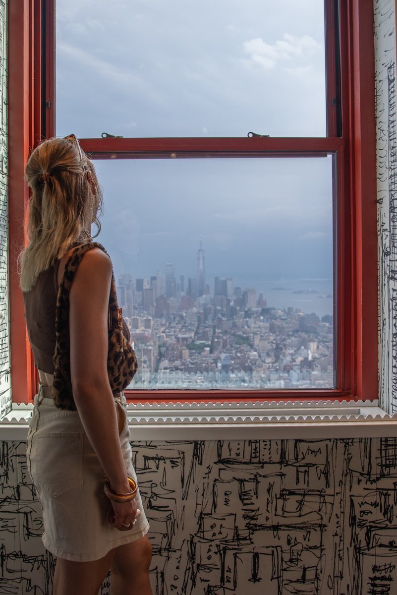 Femme qui regarde à travers une fenêtre rouge