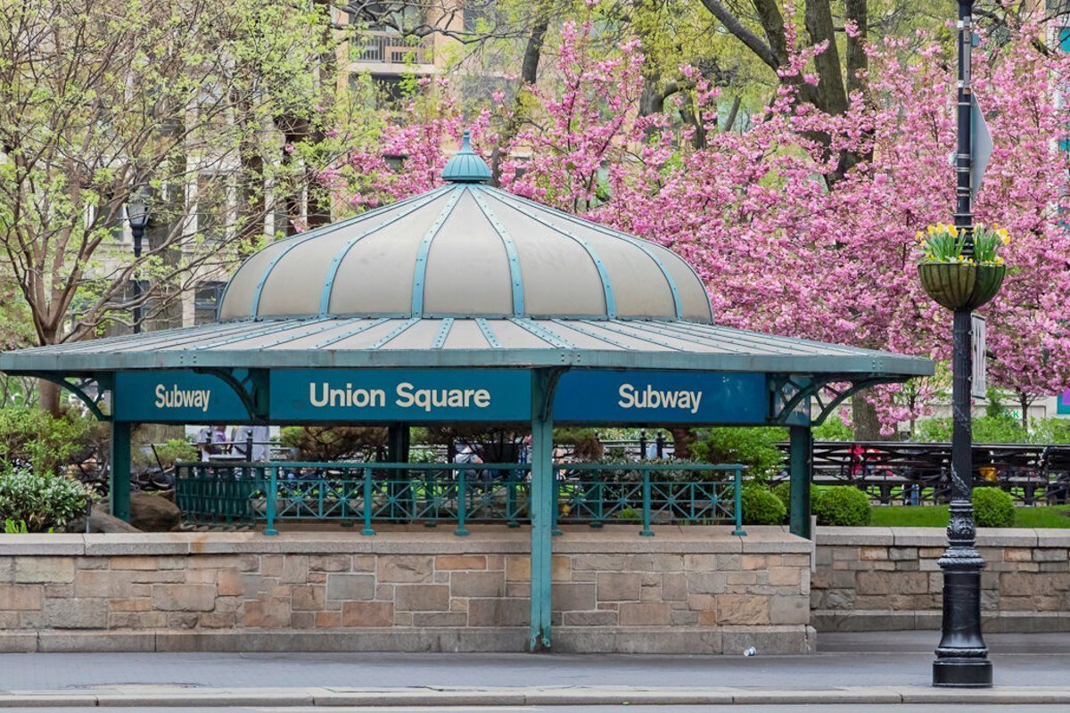 New York City subway station entrance in Union Square Park with colorful spring flowers